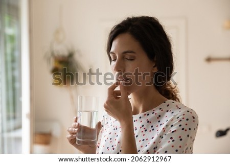 Stressed tired woman taking vitamins, painkillers, antidepressants, pills, meds against headache, insomnia, nervous disorder, anxiety. Patient with medication fighting against flu infection, migraine Royalty-Free Stock Photo #2062912967