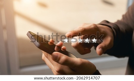 A male customer gives a five-star rating on their smartphone, satisfaction, customer service experience. Service Rating Reviews and Satisfaction Survey Concept. Royalty-Free Stock Photo #2062914707