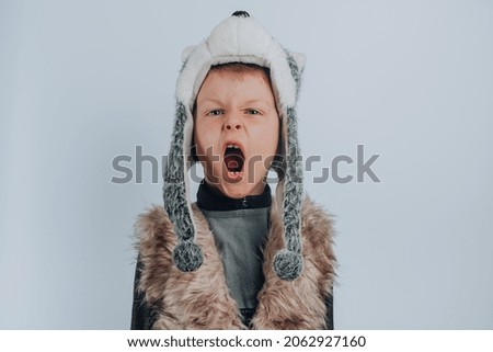 Boy in a wolf costume roaring, isolated on gray background. High quality photo