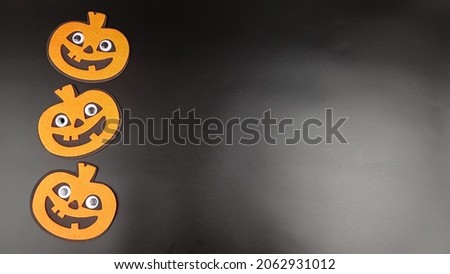 an image of cheerful orange pumpkins on a black background. there are places for a copy of space