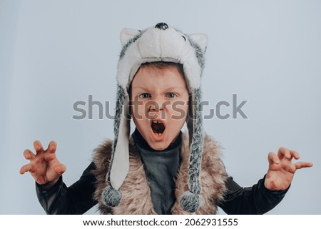Boy in a wolf costume, isolated on gray background