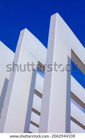 Concrete columns and abstract architecture contrast with the blue sky. Beautiful and clear light. Modern architecture and building concepts.