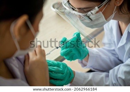 Young woman visits skillful doctor at hospital for vaccination . Covid 19 and coronavirus vaccination center service concept .