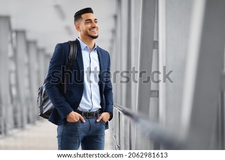Ready For Trip. Handsome Arab Man With Backpack Standing At Airport Terminal And Looking At Window, Smiling Middle Eastern Man Waiting For Flight Departure, Enjoying Air Travels, Copy Space Royalty-Free Stock Photo #2062981613