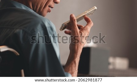 Hand of senior man with disability holding mobile phone with smiley face speaking to connection with family or business by him self, Technology and social media concept.