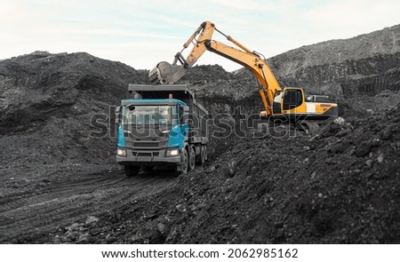 Large quarry dump truck. Loading the rock in dumper. Loading coal into body truck. Production useful minerals. Mining truck mining machinery, to transport coal from open-pit as the Coal Production Royalty-Free Stock Photo #2062985162