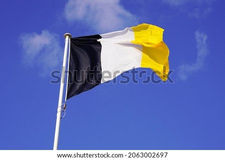 Flag of Arcachon town southwest waving in the air on blue sky in France