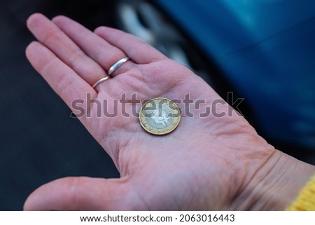 Old Bitcoin coin in the palm of your hand. a girl holds a worn coin in her hand
