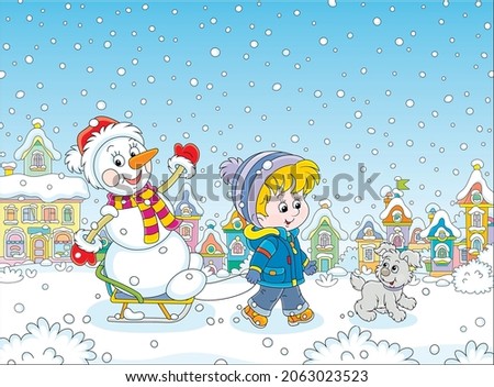 Happy little boy walking with his merry pup and sledding a funny snowman down a snow-covered street of a pretty small town on a beautiful snowy winter day, vector cartoon illustration