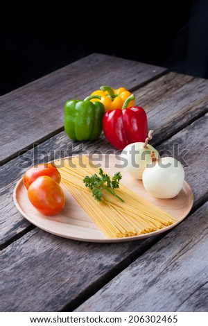 Ingredients for spaghetti on wood table.