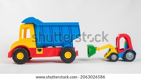 Truck and excavator. Plastic toy multicolored cars isolated on white background.
