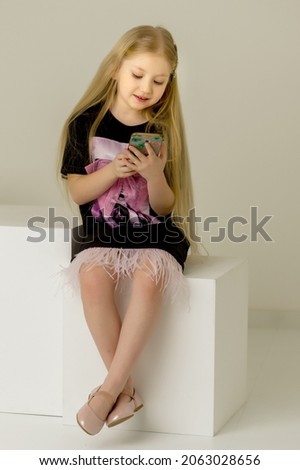 The girl is using a cell phone.The concept of people and technology.
