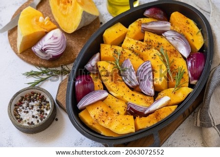 Raw pumpkins slice with rosemary and purple onion, baking fresh healthy food with spice on a gray stone background. Keto or paleo diet veggie vegan or vegetarian. 