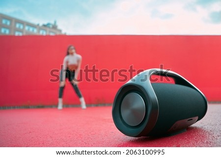 Wireless outdoor portable speaker template on dance floor podium on red background with copy space for advertisement