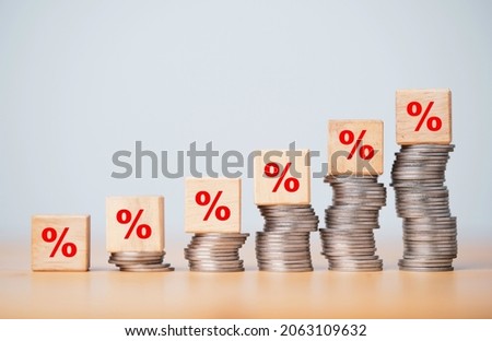 Percentage sign print screen on wooden cube block which lay down on increasing coins stacking for interest rate and business profit growth concept.