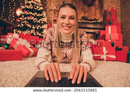 Photo of charming pretty mature woman wear print sweater smiling typing new year wishes indoors house home room