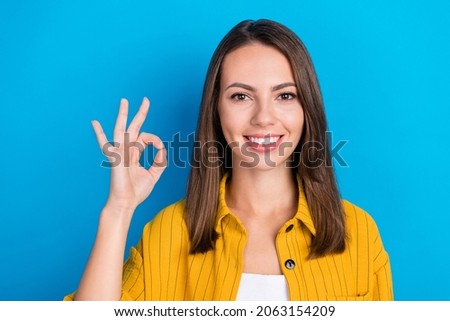 Photo of cheerful charming young woman make okay sign recommend advert isolated on blue color background