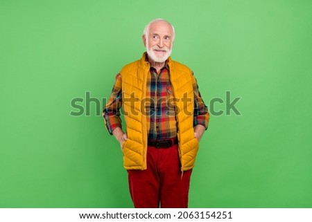 Photo of dreamy sweet mature man dressed yellow waistcoat smiling looking empty space isolated green color background