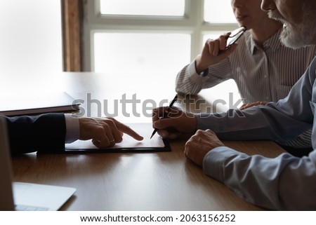 Sign here please. Close up of lawyer manager in formal attire show retired couple customers place to sign insurance contract bank deposit agreement. Senior spouses clients close deal in realtor office Royalty-Free Stock Photo #2063156252