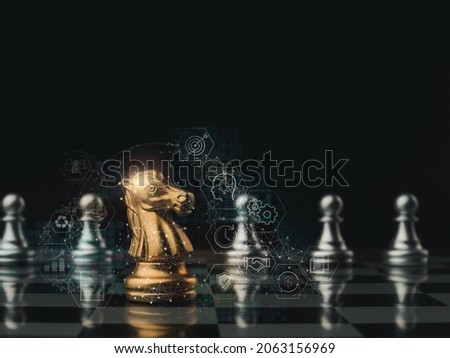 The golden horse, knight chess piece standing in front of silver pawn chess pieces on chessboard on dark background. Leadership, follower, team, commander, competition, and business strategy concept. Royalty-Free Stock Photo #2063156969