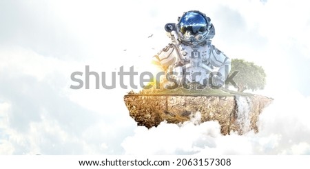 Astronaut against cloudy sky background . Mixed media