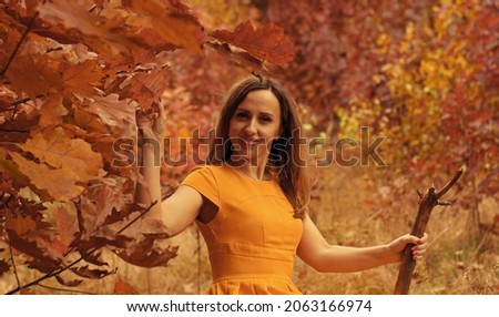 
In the autumn forest portrait of a girl in a yellow dress