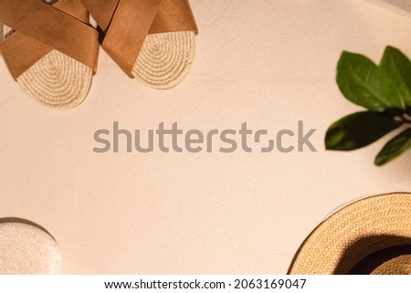 Beach background with brown sandals and stone on a sandy beach in the sun. Concept: Summer vacation in a warm country. 