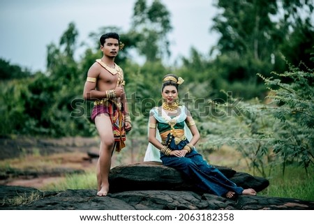 Portrait of Young man and woman wearing beautiful traditional costume which Imagination image of Thailand literature about Serpent king, Folk tales based on belief of the Isan, pose in nature outdoors