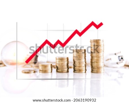 Graphic on coin towers showing the rise in the price of electricity. Selective focus Royalty-Free Stock Photo #2063190932