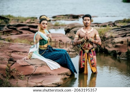 Portrait of Young man and woman wearing beautiful traditional costume which Imagination image of Thailand literature about Serpent king, Folk tales based on belief of the Isan, pose in nature outdoors