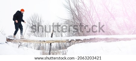 A man in the winter in the forest. A tourist with a backpack goes through the woods in winter.