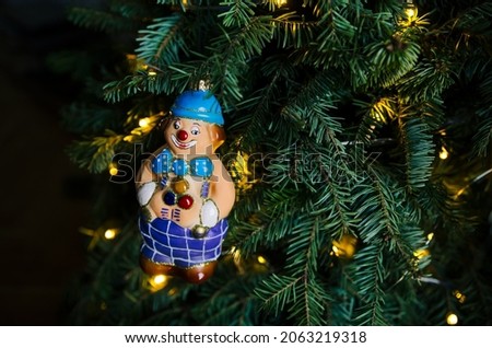 Decorated branch of the New Year tree. Christmas toy in the form of a clown. New Year 2022 and Christmas holiday concept.