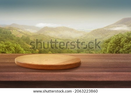 Empty wooden plate on the table with Mountain soft blurry background, of free space for your copy and branding. Use as products display montage. Vintage style concept. Royalty-Free Stock Photo #2063223860