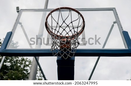 Basketball Shield with a ring in the backyard. Home yard with basketball court. Royalty-Free Stock Photo #2063247995