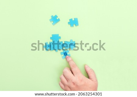 Businessman connecting pieces of a puzzle with a picture of dollars and a box with a gift. Sales increase concept.