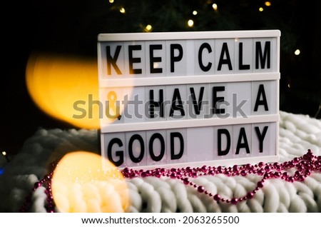 Motivational lightbox with the words Keep calm and have a nice day. The photo is decorated with New Year's golden bokeh.