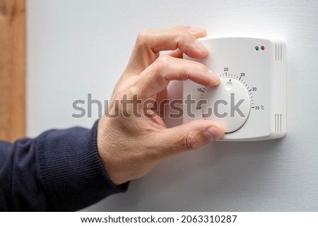 Central Heating thermostat control dial adjustment Royalty-Free Stock Photo #2063310287