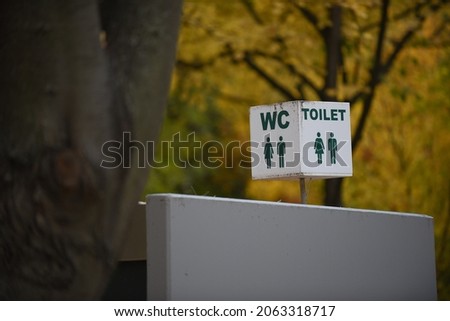 Label of symbol of toilet for men and women in the park