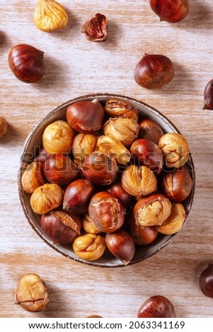 Chestnuts, shot from the top on a rustic wooden background in a bowl Royalty-Free Stock Photo #2063341169