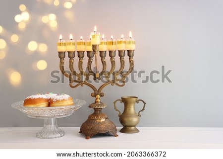 Religion image of jewish holiday Hanukkah background with menorah (traditional candelabra), doughnut and oil candles