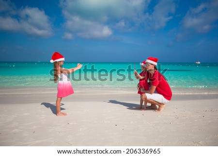 Cute girl making photo on phone father and sister at the beach