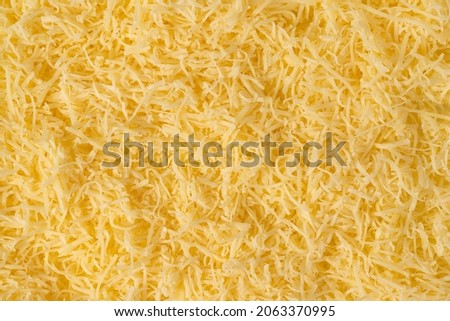 Grated cheese background texture. yellow shredded  cheese. Close up top view.