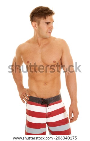 a man looking to the side wearing his red and white swim shorts.