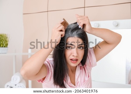 Stressed woman with graying hair at home Royalty-Free Stock Photo #2063401976