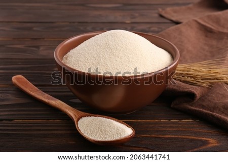 Uncooked organic semolina and spikelets on wooden table Royalty-Free Stock Photo #2063441741