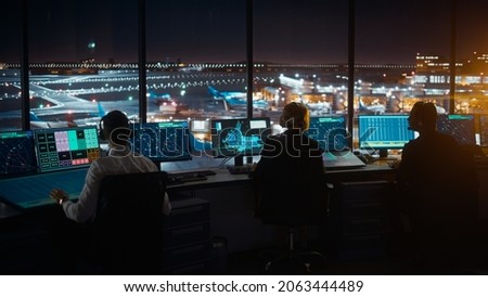 Diverse Air Traffic Control Team Working in Modern Airport Tower at Night. Office Room Full of Desktop Computer Displays with Navigation Screens, Airplane Departure and Arrival Data for Controllers. Royalty-Free Stock Photo #2063444489