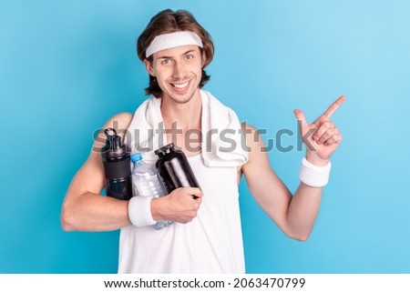 Photo portrait strong man keeping plastic bottle with supplements in gym pointing copyspace isolated pastel blue color background