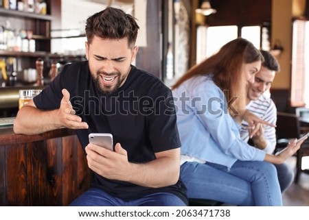 Sad young man after losing of his sports bet in pub Royalty-Free Stock Photo #2063471738
