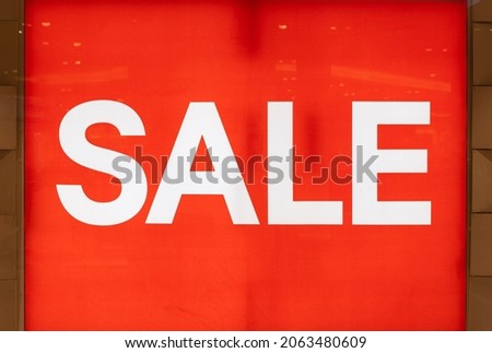 big sale word on light sign in shop glass window or wall and red background in shopping mall or department store for advertising and business marketing