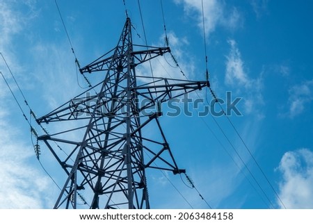 Electrical high-voltage tower on blue sky background.